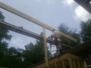 Carpenter setting a ridge beam over a new addition frame — Ice Dam Removal by Roofing Brothers in Dallesport