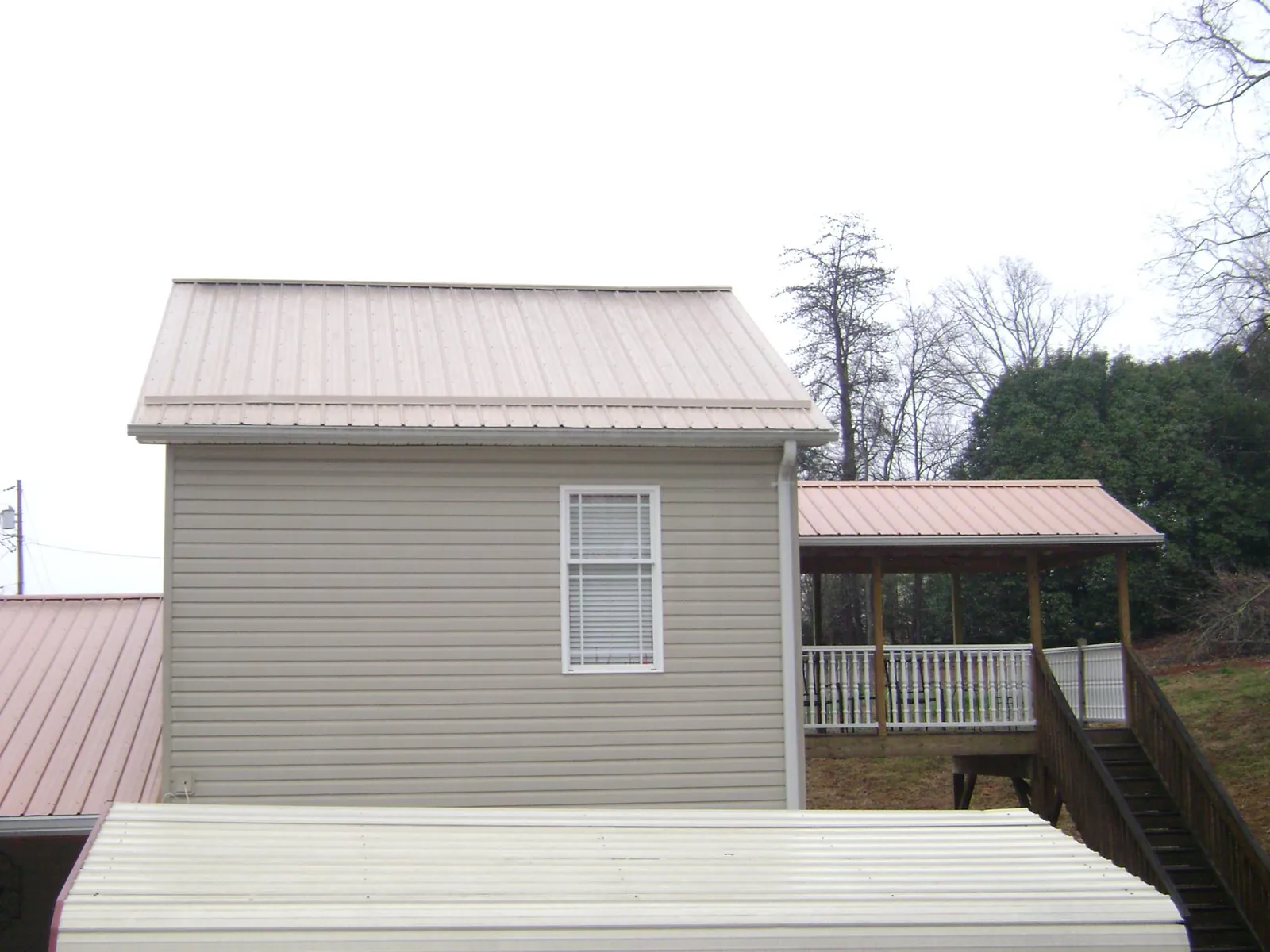 Tan metal roofs on a two story addition and attached porch, from a Roof Replacement job in Dallesport